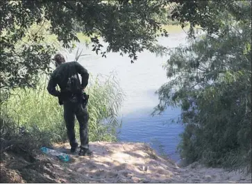  ?? John Moore Getty Images ?? A BORDER PATROL agent looks for migrants crossing the Rio Grande near McAllen, Texas, this month.
