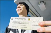  ?? JOE BURBANK/ORLANDO SENTINEL ?? UCF junior Parker Melnick holds the flight voucher after being the first in line to purchase a subsidized ticket to the 2019 Fiesta Bowl.