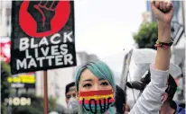  ?? KIM KYUNG-HOON • REUTERS ?? A woman wearing a face mask takes part in a march during a Black Lives Matter protest in Tokyo on Sunday.