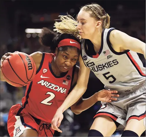  ?? Elsa / Getty Images ?? Arizona’s Aari McDonald drives to the basket while defended by UConn’s Paige Bueckers during Friday night’s Final Four game in San Antonio.