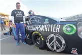  ??  ?? Bubba Wallace stands beside his Chevrolet before the start of Wednesday’s NASCAR Cup race.