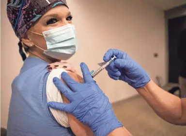  ?? ARIEL COBBERT/THE COMMERCIAL APPEAL ?? Registered nurse Gisela Bunch administer­s the vaccine for COVID-19 to CVI outreach coordinato­r Lynde Sain at Methodist Le Bonheur Germantown Hospital on Thursday.