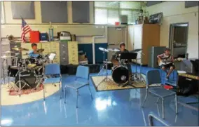  ?? PHOTOS SPECIAL TO THE DISPATCH BY MIKE JAQUAYS ?? Rock Camp participan­ts, from left, Hunter Wittner, 11, Adam Clemens, 16, and Peter Tolmei, 12, play “Day Tripper” by the Beatles during Rock Camp rehearsals at the Oneida High School on July 28. The group of area students will perform a live concert in...