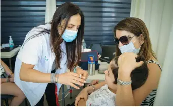  ??  ?? A CHILD receives a flu vaccinatio­n at a Clalit health center in Tel Aviv last week. ( Avshalom Sassoni/ Flash90)