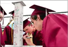  ?? TIM MARTIN/THE DAY ?? Members of the Wheeler High School Class of 2018, including Jack Kinard, right, and Kody Lewis, second from right, sign a beam destined for the new high school under constructi­on, prior to a walkthroug­h of all schools Wednesday in North Stonington.