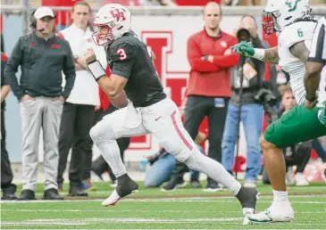  ?? Leslie Plaza Johnson/Contributo­r ?? Clayton Tune runs the ball in the first half, but he did most of his damage through the air, throwing for a season-high 380 yards. He’s now one of three 10,000-yard passers for UH, trailing only Case Keenum and Kevin Kolb.