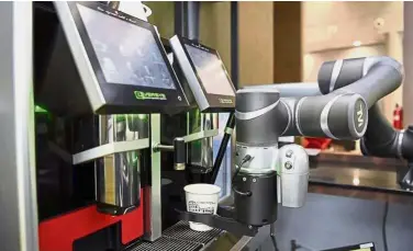  ?? — The Straits Times/Asia News Network ?? At the smart cafe, robot baristas use facial recognitio­n technology to serve regular customers coffee suited to their tastes.