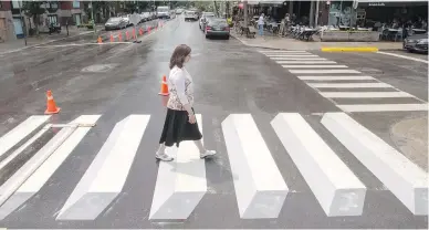 ?? RYAN REMIORZ, CP ?? A pedestrian walks on one of two new 3D-style crosswalks in the Montreal borough of Outremont.