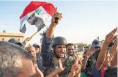  ?? Fadel Senna / AFP / Getty Images ?? Iraqi federal police wave the national flag Sunday as they celebrate the “liberation” of Mosul from Islamic State militants.