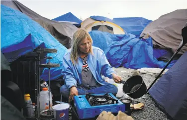  ?? Lea Suzuki / The Chronicle ?? Samantha Howell makes coffee as she prepares dinner at Last Chance Village for homeless in Santa Rosa.