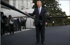  ??  ?? President Donald Trump talks to the media as he walks from Marine One to the White House in Washington on Wednesday as he returns from Indianapol­is. AP PHOTO/CAROLYN KASTER