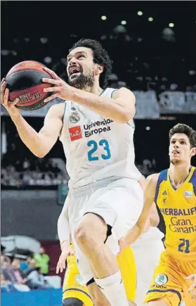  ?? FOTO: EFE ?? Llull encara el aro perseguido por Paulí. Al Madrid le costó mucho imponerse