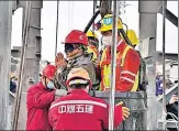  ?? REUTERS ?? Rescue workers help a miner as he is brought to the surface at the Hushan gold mine in Qixia, Shandong province, China.