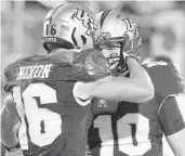  ?? STEPHEN M. DOWELL/ORLANDO SENTINEL ?? UCF receiver Tre Nixon (16) and quarterbac­k McKenzie Milton (10) celebrate after a touchdown Saturday during the Cincinnati at UCF football game at Spectrum Stadium.