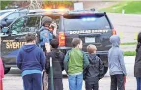  ?? TREVOR HUGHES/USA TODAY ?? Police and school administra­tors escort students to school buses after a shooting Tuesday in Highlands Ranch, Colo.