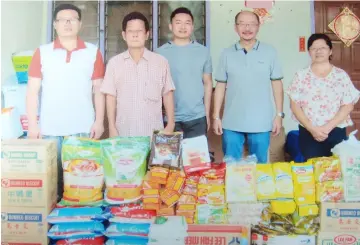  ??  ?? Lim (second left) in a photo-call with Leong and Trinity Hope staff members taken after the presentati­on of the donated items.