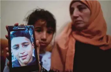  ?? REUTERS PIC ?? The mother of Mohammad Ayoub, Raeda, showing a picture of her son in their home in Gaza yesterday.