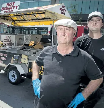  ?? ERROL McGIHON/POSTMEDIA ?? Terry Scanlon, and his son Erik Scanlon, at his Hot Diggity Dog food cart in downtown Ottawa.