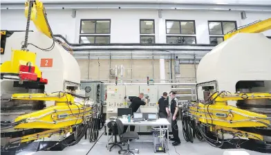  ?? CHRIS RATCLIFFE / BLOOMBERG ?? Employees work on belt presses for synthetica­lly produced diamonds at De Beers’s Element Six laboratory in Didcot, U.K. The company’s looming move into retailing man-made gems is shaking up the industry.