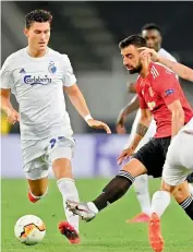  ??  ?? Manchester United’s Bruno Fernandes (in red) vies for the ball with FC Copenhagen’s Jason Wood (left) during their UEFA Europa league quarterfin­al match in Cologne, Germany, on Monday. United won 1-0.