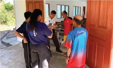  ??  ?? Wan (third right) is briefed by Taser (second right) on the condition of Kampung Muk Ayun, which has no electricit­y or water supply.