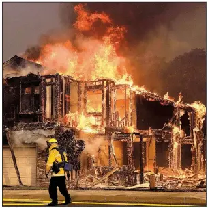  ?? AP/JEFF CHIU ?? A firefighte­r keeps an eye on fire consuming a home Monday in Santa Rosa, Calif.