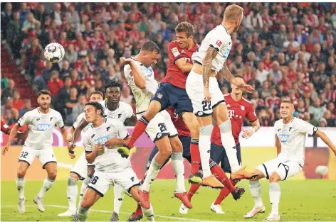  ?? FOTO: RTR ?? Das erste Tor der Bundesliga­saison 2018/19: Thomas Müller (rotes Trikot, Mitte) köpft zum 1:0 gegen Hoffenheim ein. Adam Szalai (28) kommt zu spät.