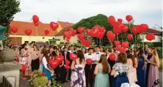  ?? Fotos: Johann Eibl ?? Ihre Wünsche an die Zukunft schickten die Abschlusss­chüler mit roten Luftballon­s in den Himmel.