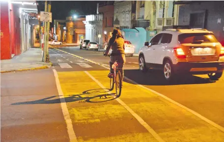  ??  ?? Un ciclista circula de noche por la bicisenda. La pintura deteriorad­a no es reflectiva, faltan carteles y las tachas están rotas.