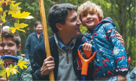  ??  ?? Justin Trudeau a planté des arbres en compagnie de jeunes enfants. - La Presse canadienne: Frank Gunn