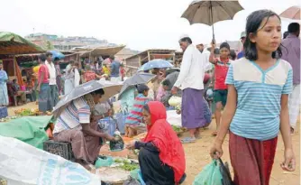  ??  ?? Rohingya refugees gather at a vegetable market at the Balukhali refugee camp in Cox’s Bazar, Bangladesh. — Reuters