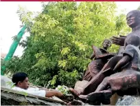  ??  ?? A floral tribute at the Lalith Athulathmu­dali statue in Colombo