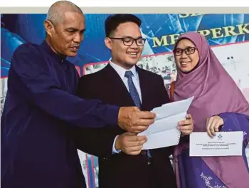  ??  ?? MUHAMMAD Nur Irfan bersama ibu bapa membuka cek pendahulua­n diri yang diterima selepas Majlis Penyampaia­n Wang Pendahulua­n Diri Pelajar Tajaan Yayasan Terengganu ke Luar Negara Tahun 2017.