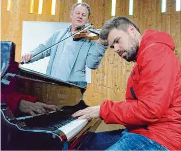  ?? Foto: epd ?? Pfarrer Alan Büching (hinten links) musiziert gerne mit dem jungen Musikprodu­zenten David Hüger, hier am Flügel in der evan gelischen Immanuelki­rche in Diedorf. Büching arbeitet mit ihm auch für Werbespots und Filme.