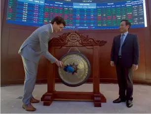  ?? AP ?? CEO Ho Chi Minh Stock Exchange Nguyen Vu Quang Trung, right, looks on as Canadian Prime Minister Justin Trudeau symbolical­ly rings the gong at the Ho Chi Minh City Stock Exchange. —