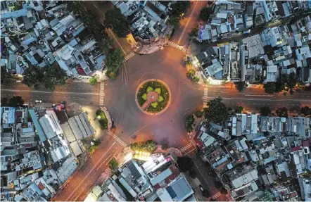  ?? — ap ?? Ghost town: an aerial views of an empty intersecti­on in ho Chi Minh City. tighter anti- virus measures have forced many locals to leave cities and return to their hometowns.