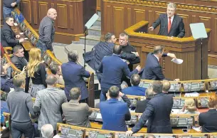  ?? AFP ?? MPs react as Ukrainian President Petro Poroshenko delivers his speech from parliament tribune ahead of a parliament­ary vote on his request to impose martial law in the country.