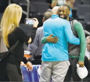  ?? Bob Leverone / Associated Press ?? Boston Celtics’ Kemba Walker, a former Charlotte Hornet, hugs old friends before an NBA game between the teams in Charlotte, N.C., on Thursday.