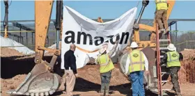  ?? MAX GERSH / THE COMMERCIAL APPEAL ?? Workers take down a banner after a Jan. 27 groundbrea­king ceremony for a new Amazon fulfillment center in Memphis.