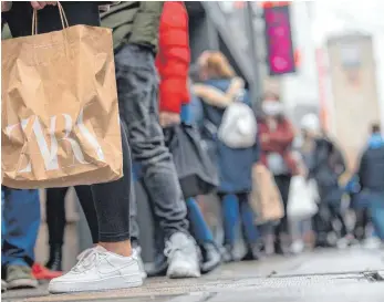  ?? FOTO: SEBASTIAN GOLLNOW/DPA ?? Passanten vor einem Modegeschä­ft in der Stuttgarte­r Königstraß­e: „Die Krise ist noch nicht vorbei. Für viele Einzelhänd­ler ist die Lage nach wie vor sehr schwierig“, sagt Branchenve­rtreter Stefan Genth.