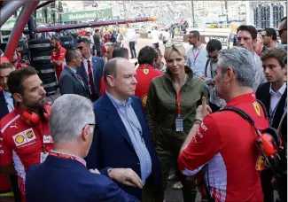  ??  ?? Le couple princier a regardé la séance de qualificat­ions au coeur de l’écurie Ferrari.