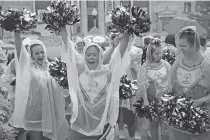  ?? THE ASSOCIATED PRESS ?? Alicia Gogue, center, and her “Starz” teammates from Maryland cheer despite falling rain minutes before Special Olympics’ 50th anniversar­y opening ceremonies Friday outside Soldier Field in Chicago.