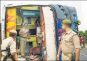  ?? PTI ?? Police personnel inspect the bus which overturned after hitting a road divider in Mainpuri on Wednesday,