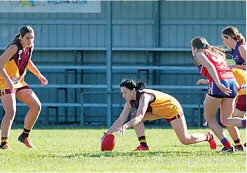  ?? ?? Drouin’s Olivia Douglas leans down to scoop up the ball and Leesa Guastella (left) waits to receive a handball.