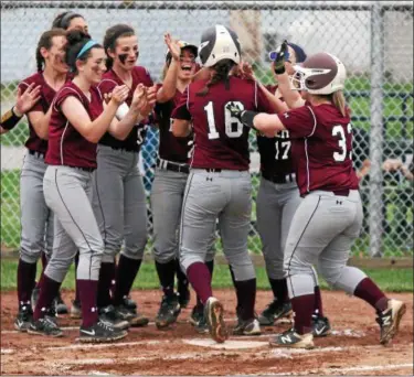  ?? RANDY MEYERS — THE MORNING JOURNAL ?? Rocky River’s Maureen Cain is congratula­ted by her teammates after hitting a home run against Elyria Catholic.