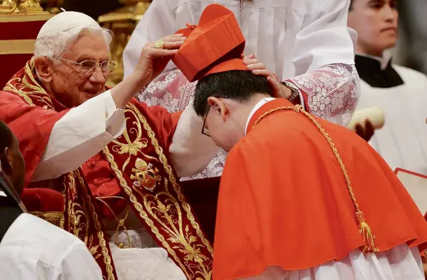  ?? AFP ?? PRINCE OF THE CHURCH Manila Archbishop Luis Antonio Tagle receives his biretta from Pope Benedict XVI during his elevation to the College of Cardinals in Rome on Saturday.