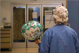  ?? JAE C. HONG / AP ?? Registered nurse Anita Grohmann carries a balloon delivered to a patient in a COVID-19 unit at St. Joseph Hospital in Orange, Calif. Thursday.