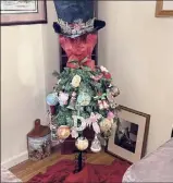  ??  ?? Nicole Weinstein and her daughter, Delia, bought an artificial tree and gave it a top hat tree topper to spice up tradition in their Albany home. It is decorated with ornaments given to them by Nicole's parents. She has 21; Delia has 17.