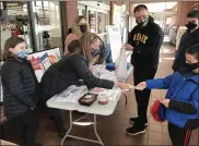  ?? STEVEN HENSHAW — MEDIANEWS GROUP ?? Declan Heywood, 9, receives change from Chrissy Twiford while his dad, Matt, gets a quart of chili during the annual Chef Tim’s Take the Chill Off fundraiser presented by Redner’s Markets. This sale was the Wyomissing Redner’s but numerous others locations were also selling the chili to benefit Blankets of Hope.The Heywoods including Declan’s older brother Matthew, 12, came to the Wyomissing store, one of several retail locations in Berks County that distribute­d pre-ordered or walk-up purchases of black angus chili made by Twiford’s husband Tim, executive chef of Redner’s, on Saturday in support of the nonprofit Blankets of Hope. Also volunteeri­ng at the table in the vestibule were Lorelai Witman, 8, and Lorelai’s mother Misty.