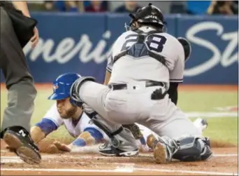  ?? FRED THORNHILL — THE CANADIAN PRESS VIA AP ?? Toronto Blue Jays’ Russell Martin (55) is tagged out at home plate by Yankees catcher Austin Romine (28) in the second inning of their American League MLB baseball game in Toronto on Sunday.